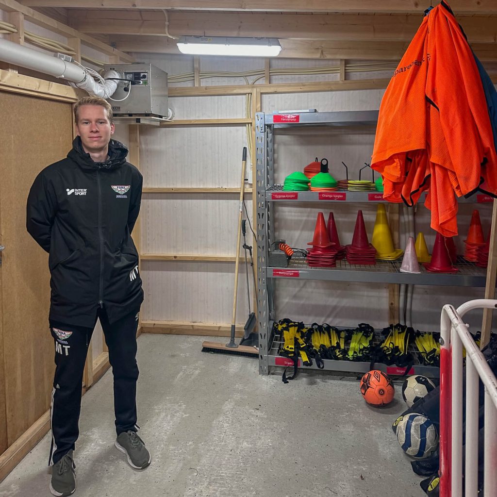 Bærekraftsansvarlig Magnus Thorsen i en tørr bod med mye utstyr lagene i Fana IL Fotball nå trygt kan dele på. 