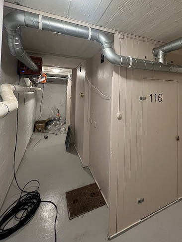 ventilasjonskanaler med avfukter i kjeller med boder, sett ved et hjørne
