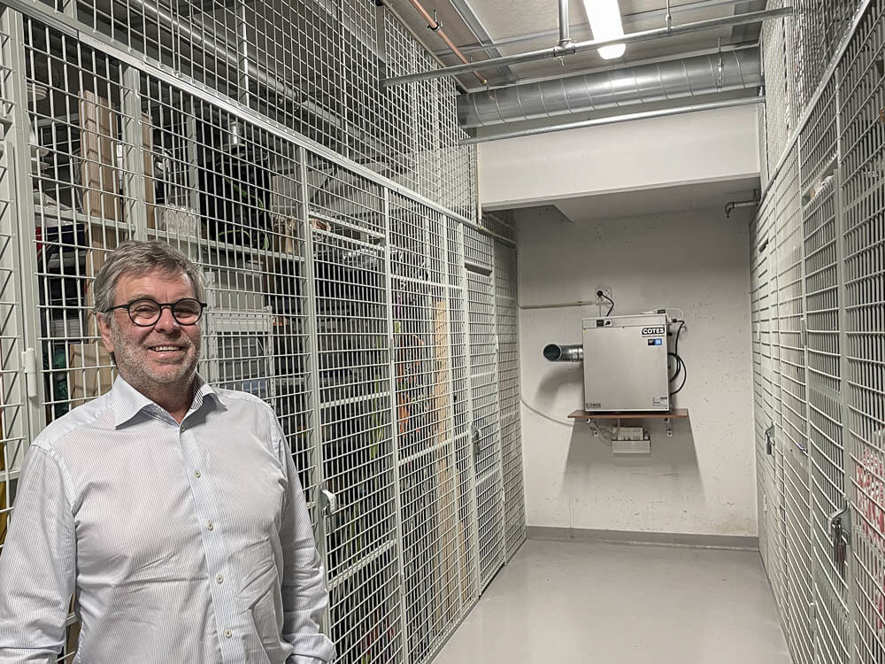 Espen Aronsen i Boligsameiet Skallumhagen ved kjellerboder med en avfukter på veggen i bakgrunnen.