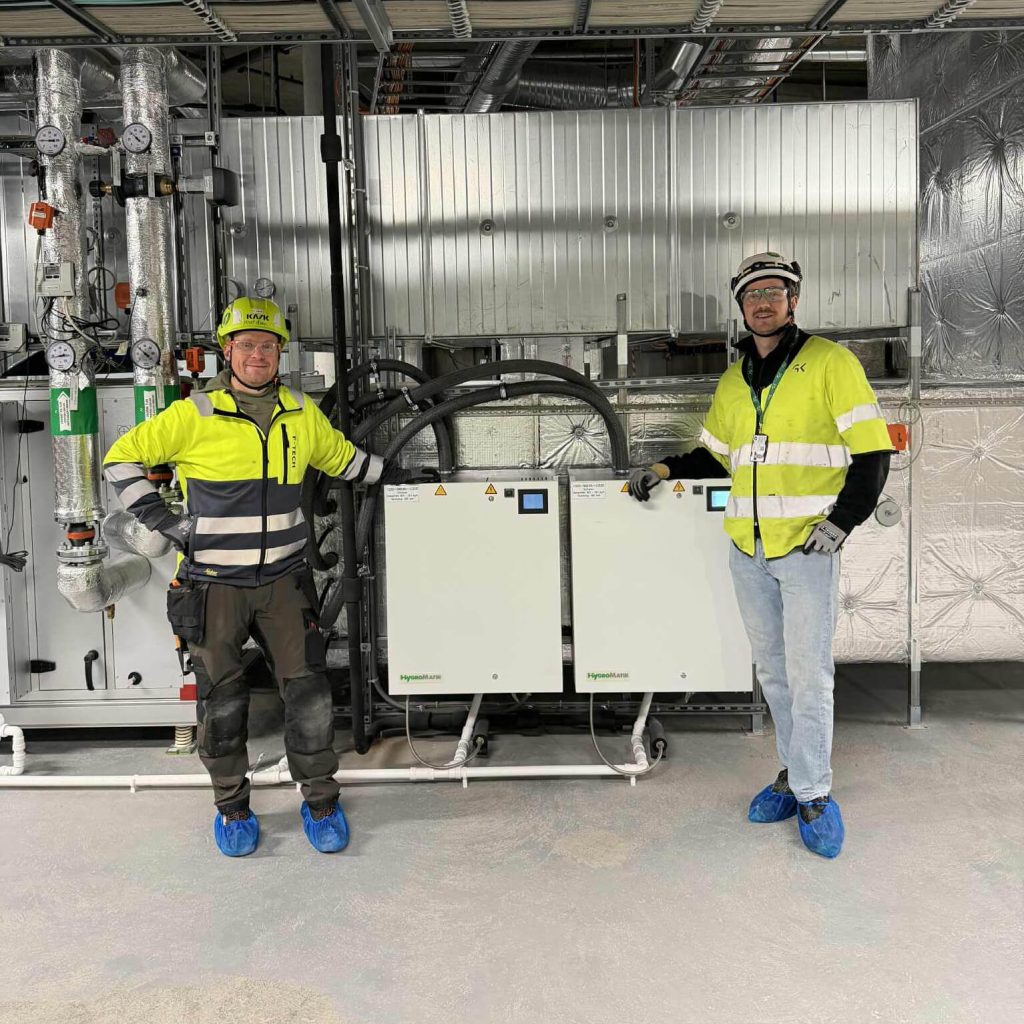 Servicetekniker Knut Åsen fra F-Tech og prosjektleder Vemund Mollestad Rislaa foran befukter i teknisk rom.