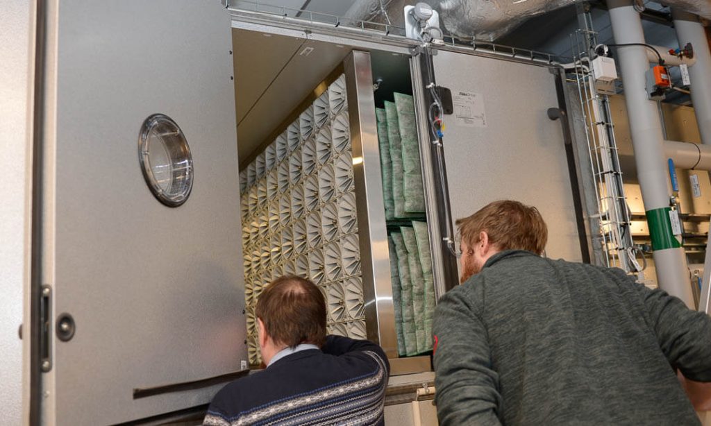 To menn kikker inn i et befukterkammer for adiabatisk kjøling