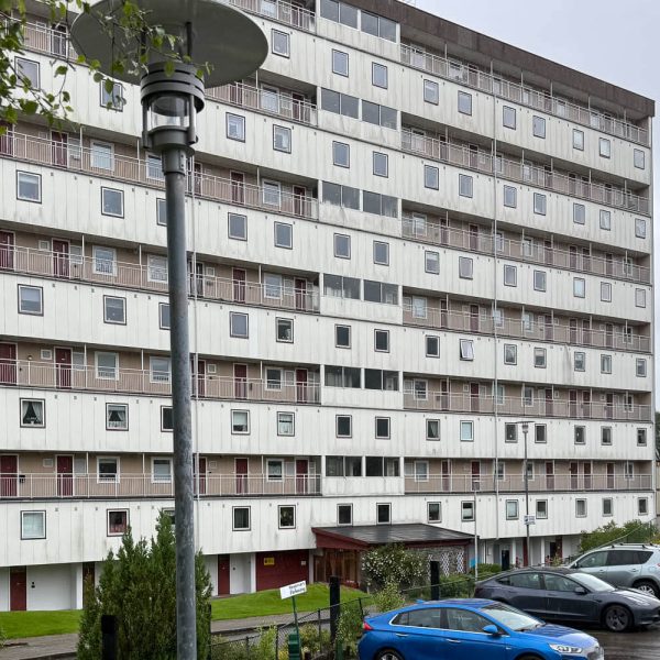 Fasade Vilhelm Bjerknesvei med biler parkert foran og en lyktestolpe i forgrunnen.