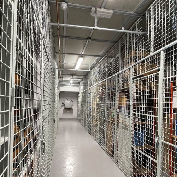 En lang rekke med boder med nettingvegger innover til en avfukter som henger på veggen innerst.